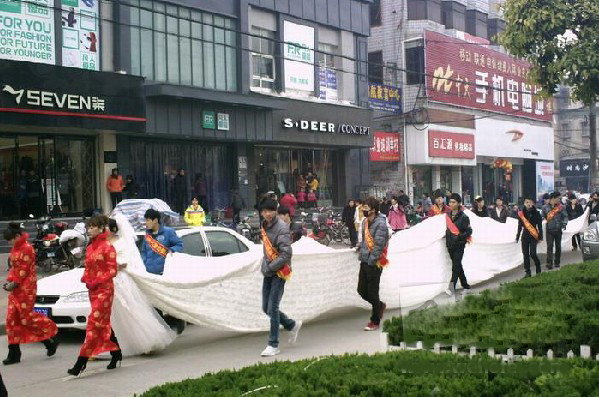 最新影楼资讯新闻-安徽阜阳惊现超牛婚纱 总长30米需20人抬着走