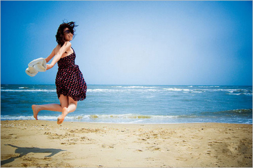 在海边飞身跃起的女孩被定格下生动瞬间