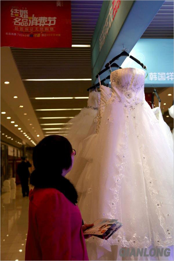 一名顾客被展出的婚纱吸引，驻留欣赏