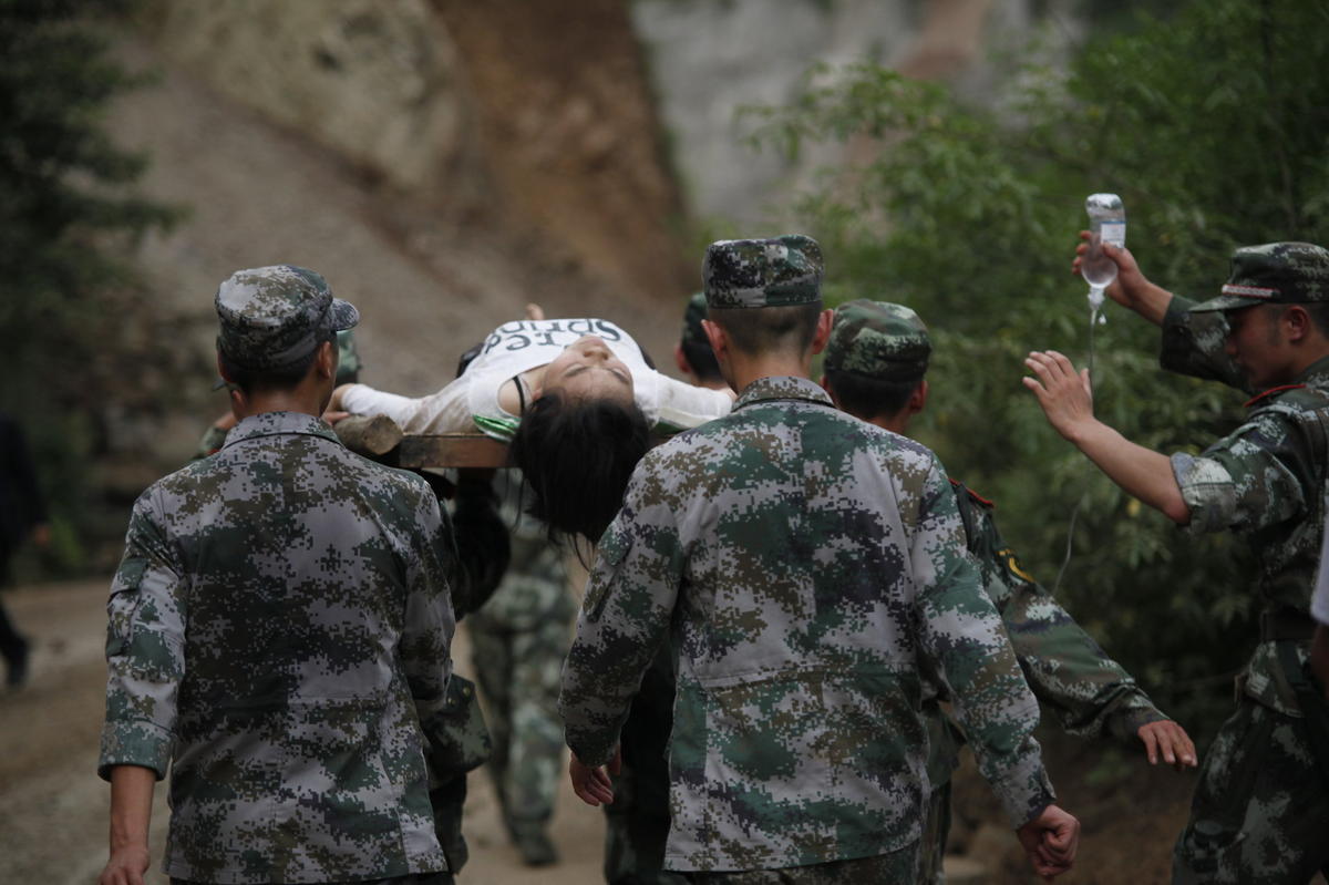 魯?shù)辇堫^山鎮(zhèn)地震現(xiàn)場，人們在余震中救死扶傷