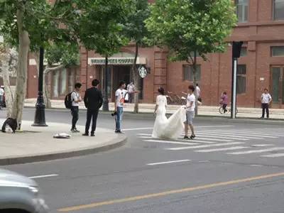 新人马路中间拍婚纱照 摄影师助理当街拦车
