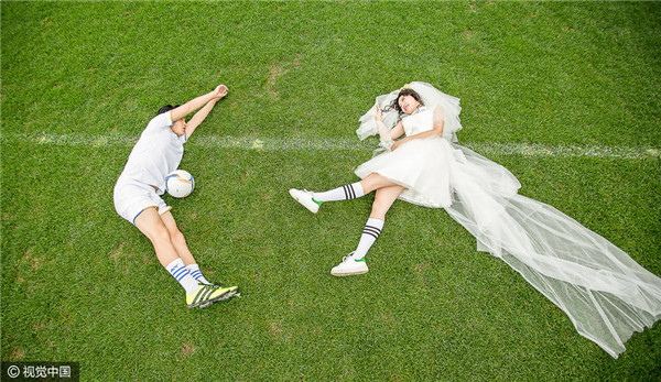 因足球相识相恋 情侣球迷拍球场婚纱照