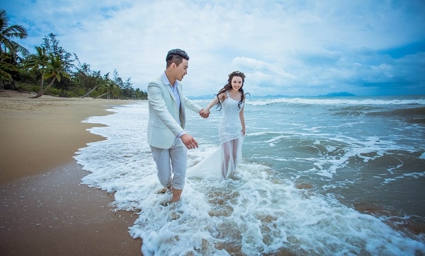 山东青岛游客不惧巨浪海边戏浪拍摄婚纱照