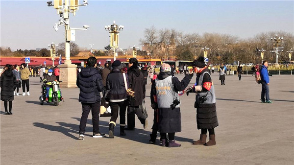 天安门广场上，寒风中给游客拍照的摄影师生意冷淡