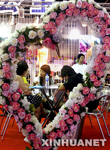 8月3日，为期3天的“2007中国(上海)婚博会”在上海光大会展中心开幕。本次婚博会展示了婚纱摄影、婚纱礼服、婚礼服务策划、婚宴酒店等全方位的结婚消费产品和服务。这是观众在婚纱摄影展台内咨询。 新华社记者刘颖摄 